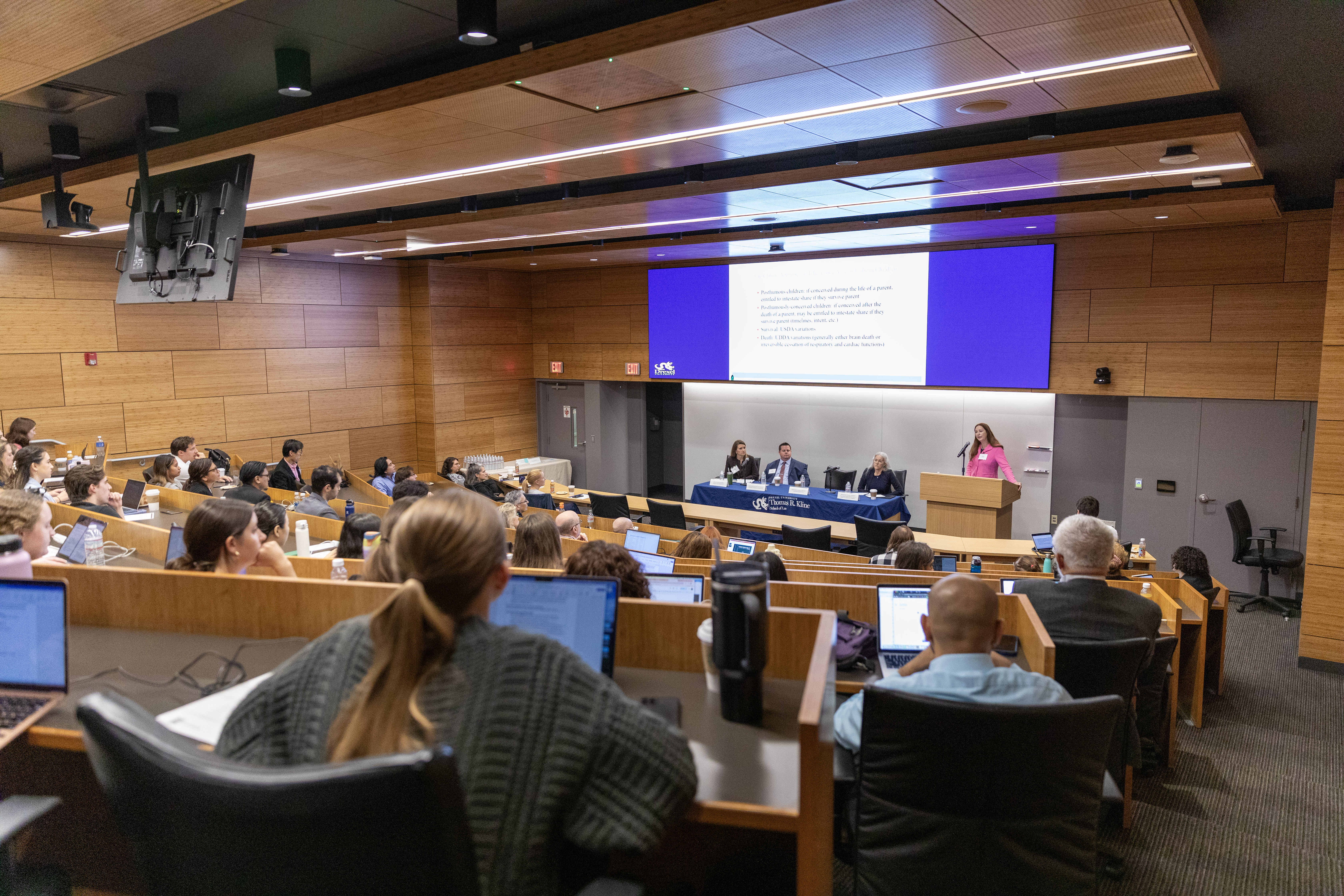 Attendees watching speaker presenting at the law review symposium