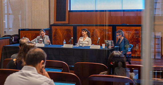 A three-person panel discusses gene and cell therapy innovation in front of an audience.