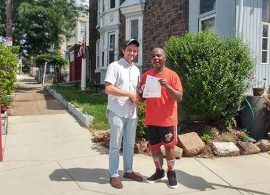 Community Lawyering Clinic student Justin Hollinger, '19, with client who was granted property deed by the court. 