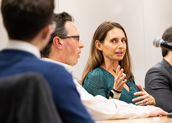 Four people sit at a table during a panel discussion.