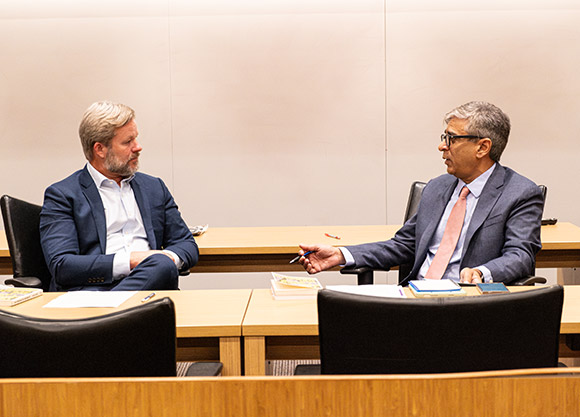 Professors Soucek and Kalhan face each other during a discussion.