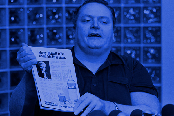 Larry Flint holds copy of Hustler magazine.
