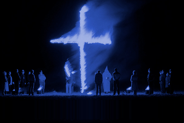 Members of the KKK burn a cross.