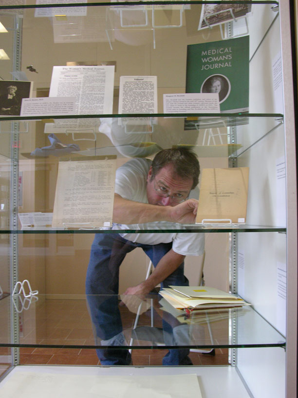 Archivist Alex Miller setting up the American Medical Women’s Association and American Women’s Hospital Service exhibit.(The Legacy Center Archives and Special Collections)