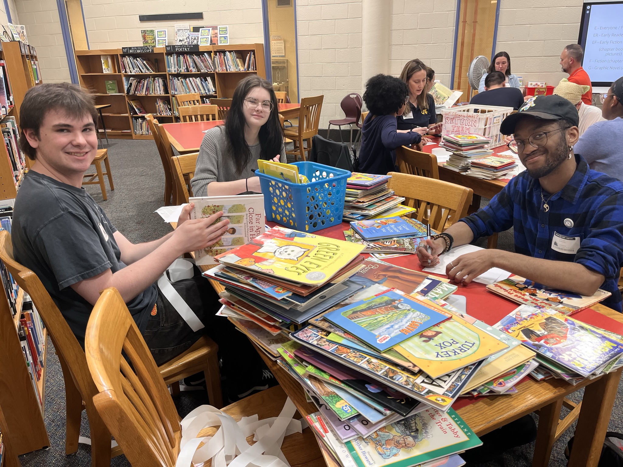 Students sitting around a table with children's books