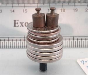 Several coins and small weights stacked on top of a sample of MXene nanocomposite