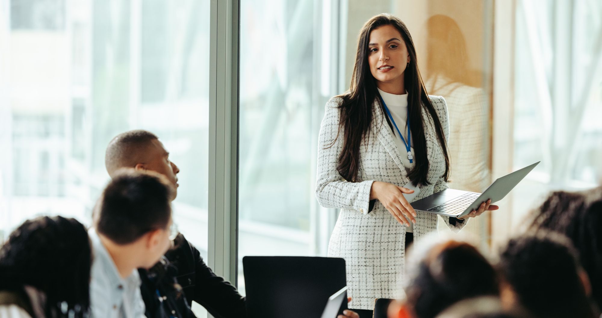 People in a conference room listening to a woman speaking