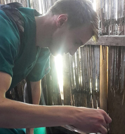 Drexel med student Garrett Mayo looking for mosquito larva in a house bathroom in Guayaquil.