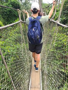 People crossing a narrow bridge from MD student Jason Lin's global health experience in Ghana