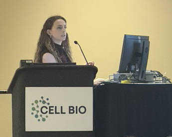 Riley Young speaking at a podium during Cell Bio 2025.