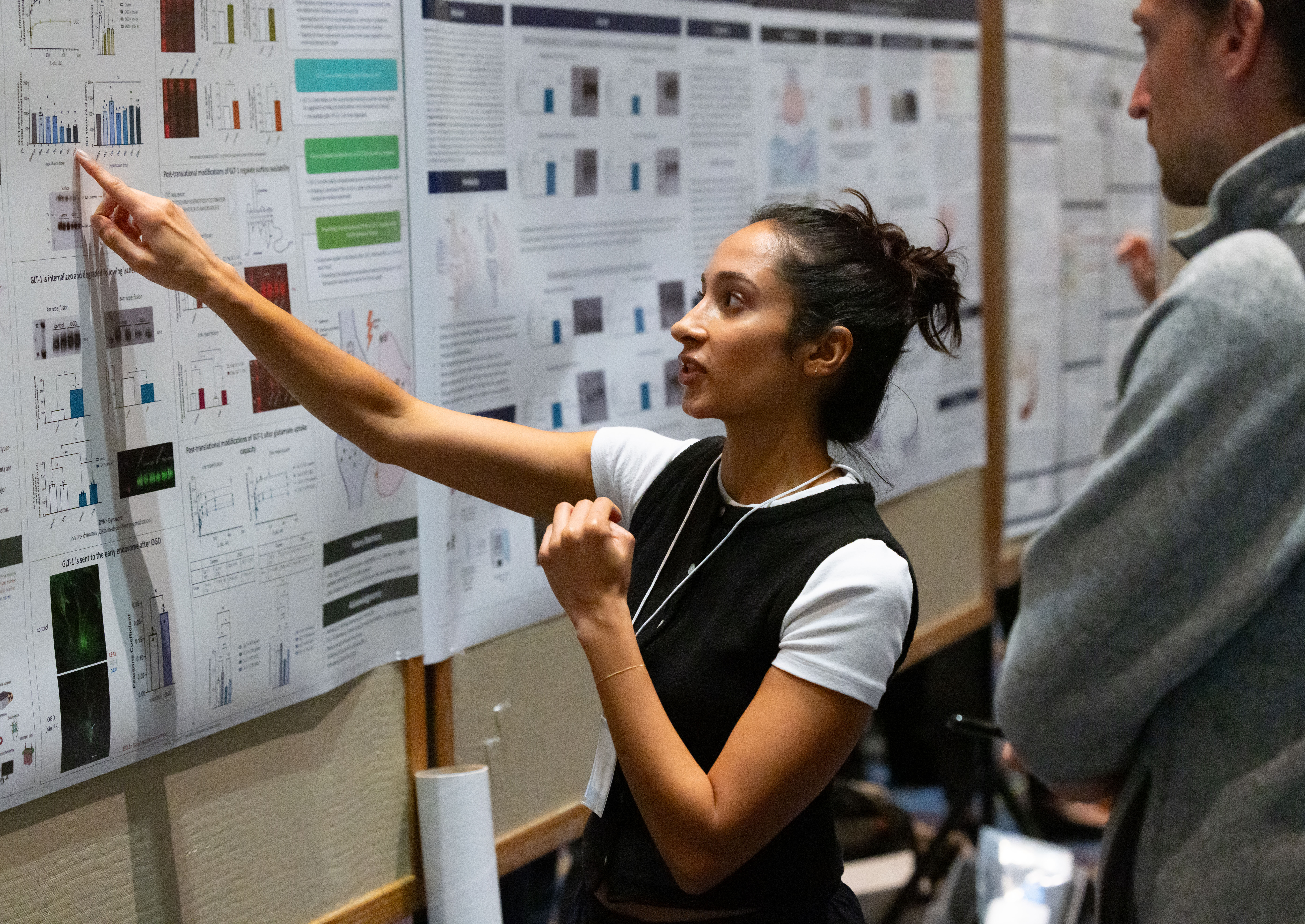 student points to poster while professor looks on