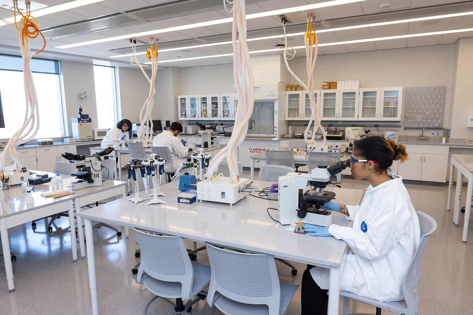 worker looking through a microscope in a lab