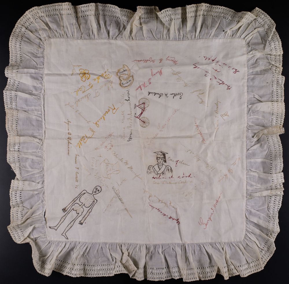 embroidered pillow sham from WMCP Class of 1896 include signatures, likeness of skeleton, graduate, bicycle
