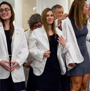 Students donning coats at the 2015 White Coat ceremony