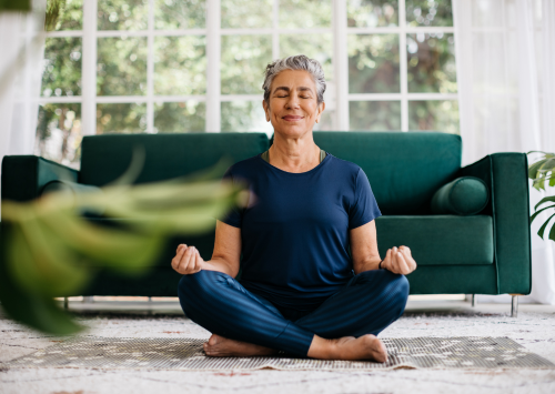 Woman meditating on living room floor
