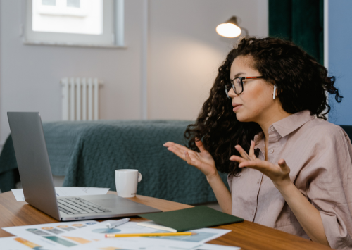 Woman working on laptop with confused body language