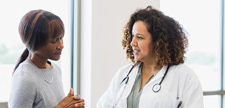 Female doctor and senior patient discuss medical records.