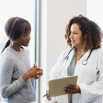 Female doctor and senior patient discuss medical records.