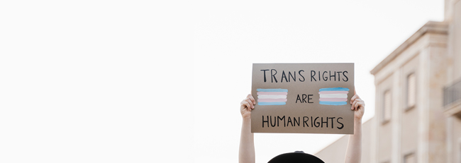 Person holding up trans rights are human rights sign.