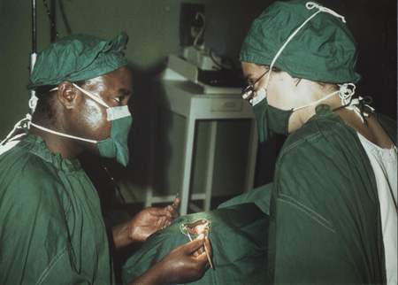 Dr. Benes (right) teaches a non-physician, 'a village barefoot doctor,' how to take out a cataract in Kenya in 1980. Note the bare hands and lack of light.