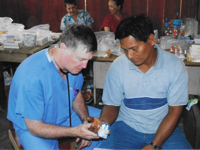 Broman examining a patient with a partially amputated finger in Iquitos, Peru, in 2009.