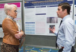 Sandra Urdaneta-Hartmann, MD, PhD, MBA Lebow ’09, discussing a Discovery Day poster with first author Bailey Balouch in 2019.