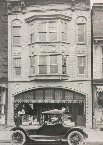 Three generations of the Simmonds family in front of the Simmonds Pharmacy in Shamokin, Pennsylvania.