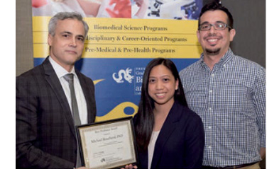 Dr. Michael Bouchard received his award from students Carlie Mendoza and Andrew Matamoros.