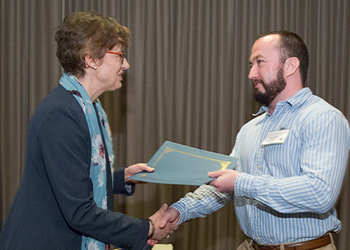 Barry DeRose receives his award from Monika Jost, PhD