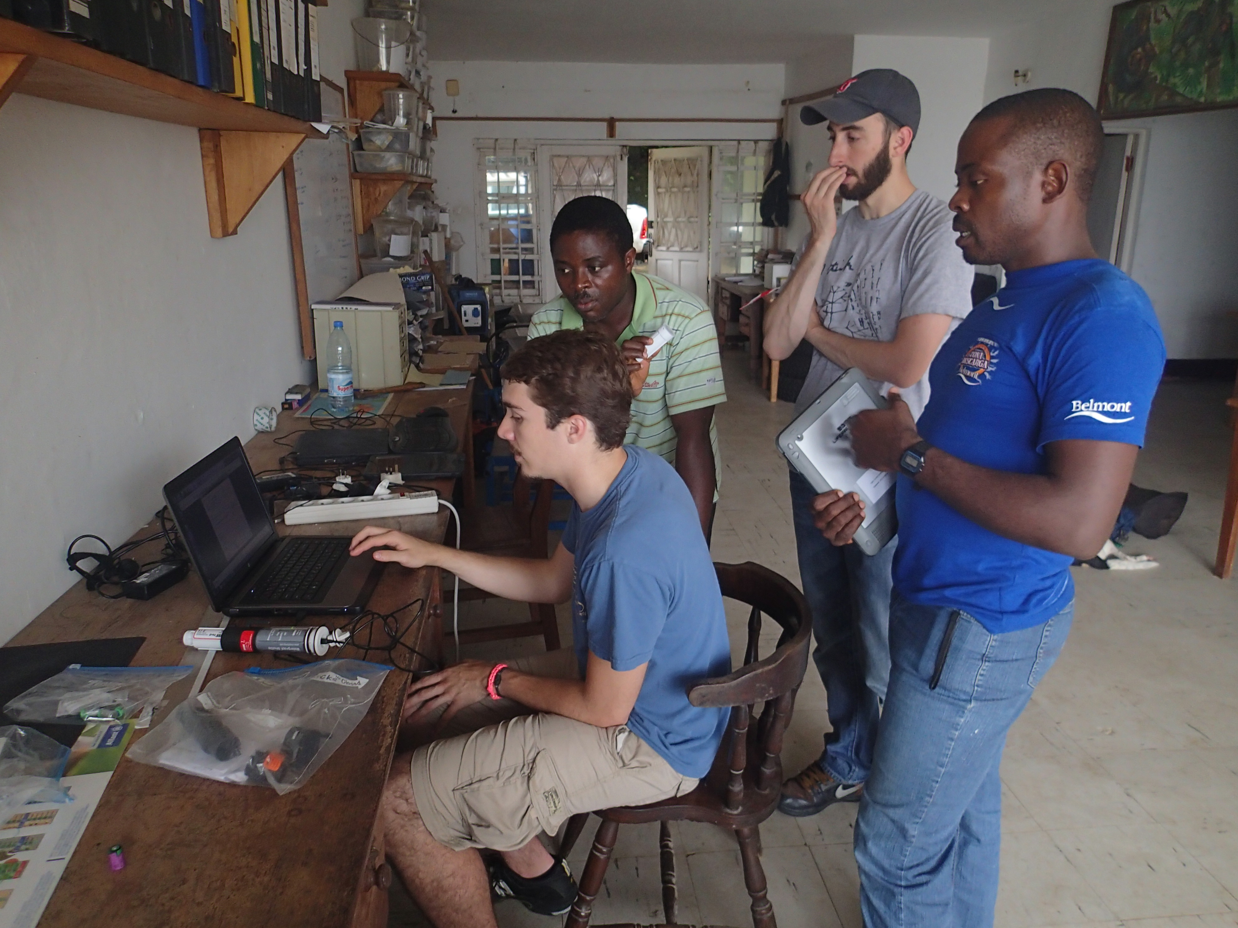 Drexel University researchers Paul Sesink Clee (seated) and Matthew Mitchell (standing, center) analyzing climate data from a field site with researchers from Ebo Forest Research Project. Credit Mary Katherine Gonder