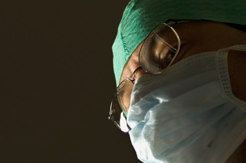 A doctor with a surgical mask on.