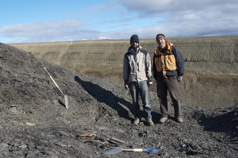 Jason Downs and Ted Daeschler side by side at the dig site with their tools.