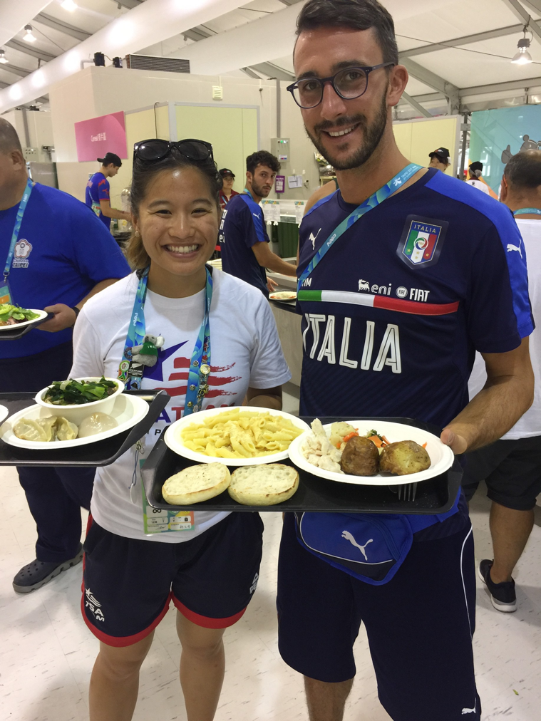 Drexel nutrition intern Leah Tsui checking out the stacked carbohydrate plate of a member of the Italian men's soccer team at the athletes village dining hall.