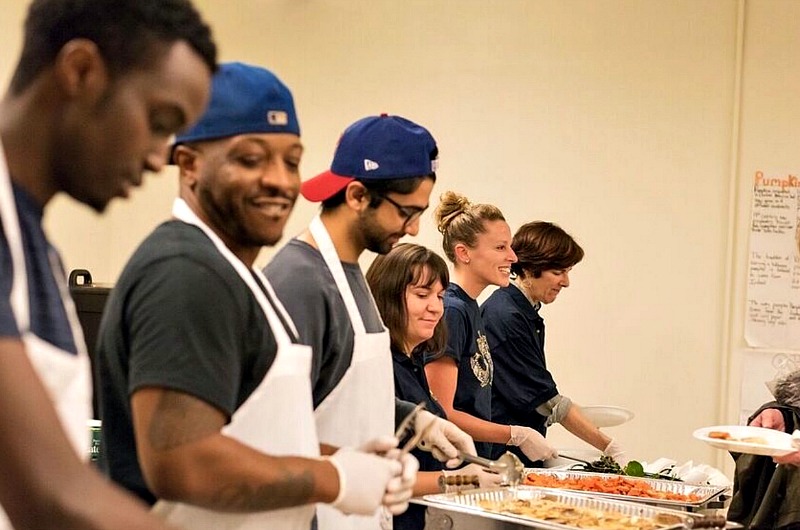 Institutional Advancement staff members Michelle Crouch, Gina Kerwin and Wendy Univer work alongside Drexel students to serve dinner to guests at the Dornsife Community Dinner on Dec. 6, 2016.
