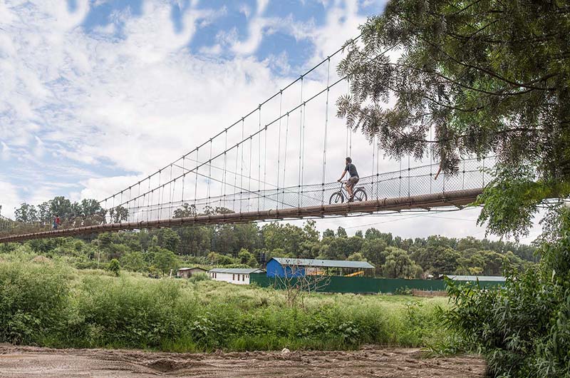 Joseph DiSalvo bikes across a bridge every day, with the bike he designed, on his way to Portal Bikes Workshop in Kathmandu, Nepal. 