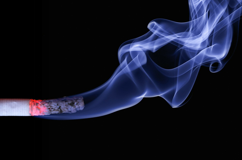 A lit cigarette with smoke wisps