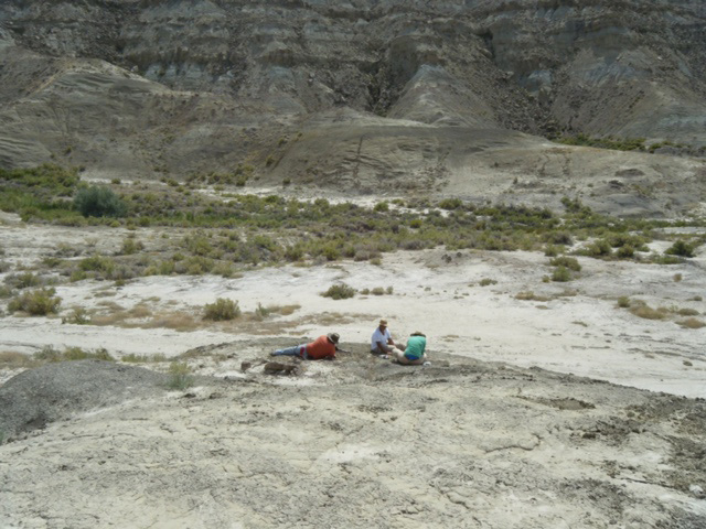 Three figures in the Montana Badlands digging.