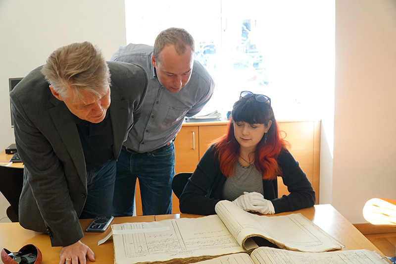 From left to right: Dornbirn archivists Werner Matt and Philipp Wittwer with Isabella Sangaline examining a primary source document at the Dornbirn City Archives during the 2018 Drexel trip to Dornbirn. Photo credit: Roxzine Scott.