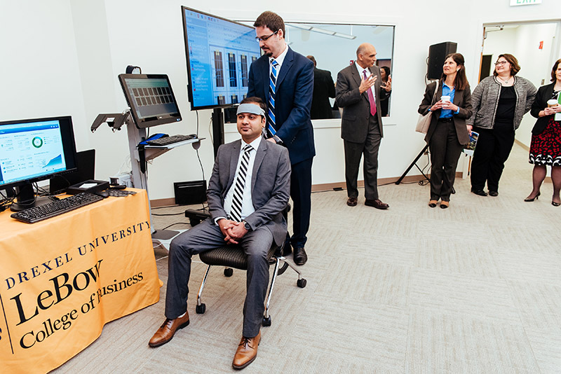 School of Biomedical Engineering, Science and Health Systems Associate Professor Hasan Ayaz, PhD, adjusted the fNIR device on then-PhD student Siddharth Bhatt, from the LeBow College of Business in this photo taken in the Behavior Lab at an event highlighting the successful partnership between SEI and Drexel University. Photo courtesy DSI. 