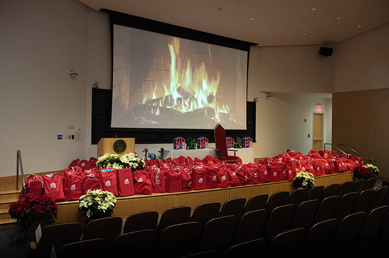 The stage at Mandell Theater with close to 200 bags filled with toys to give to community organizations at a Dec. 13 event for the Office of Government and Community Relations' 25th Annual Holiday Toy Drive. Photo credit: Kelly & Massa Photography.