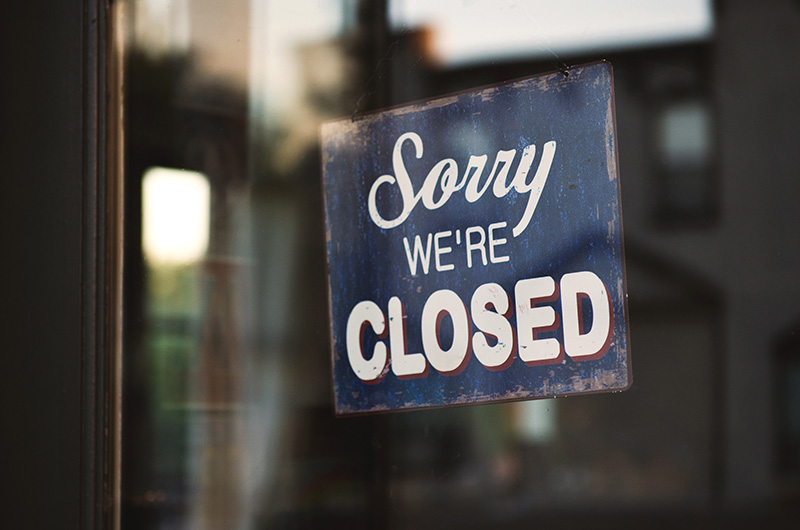 A sign on a window reading "Sorry we're closed."