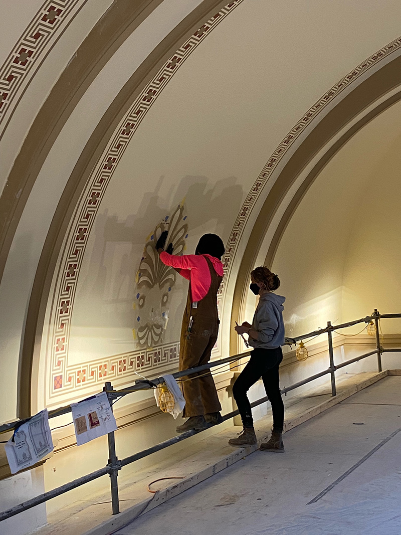 Conservators worked on adding stencil detailing in January 2022. Photo credit: Mike Thompson.