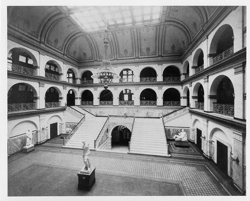 From “Drexel University: An Architectural History of the Main Building 1891–1991”: “The north side of the Great Court before the A.J. Drexel Memorial was placed on the landing of the grand staircase in 1905. The original buff and deep red decorative stenciling of the vault are evident. (Drexel University Archives.)” 