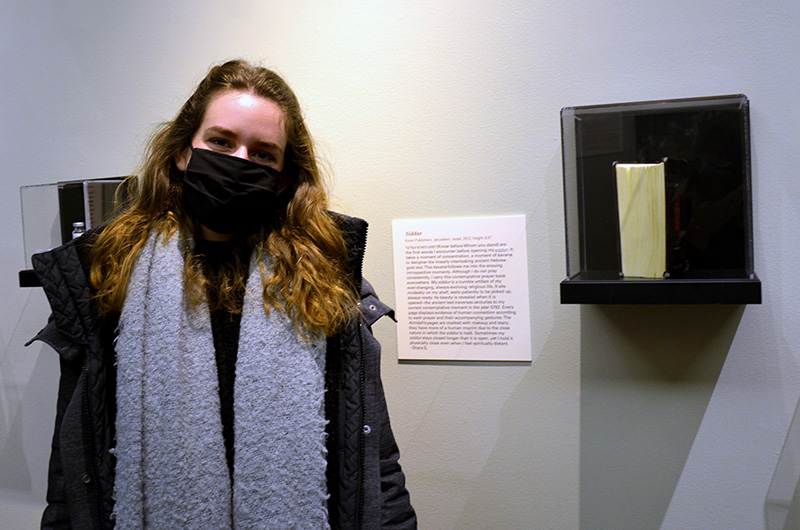 Shara Saketkhou, a fifth-year product design major who took ARTH 300 this past fall, poses with her contribution to the 'Museum of Where We Are' exhibition — a siddur, or Jewish prayer book.