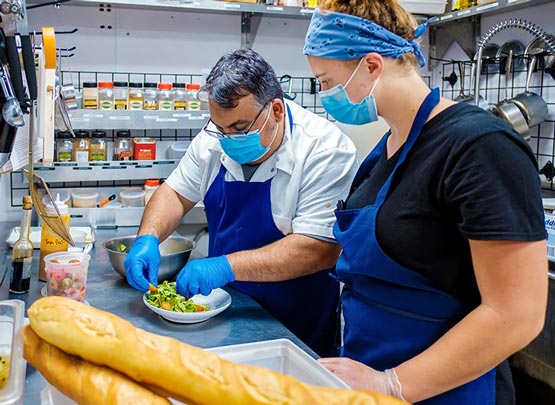 People cooking with masks on.