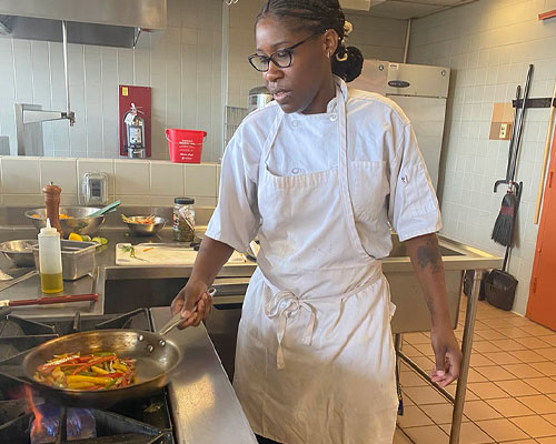 Drexel student Charmaine Patterson cooks food in the kitchen at the University