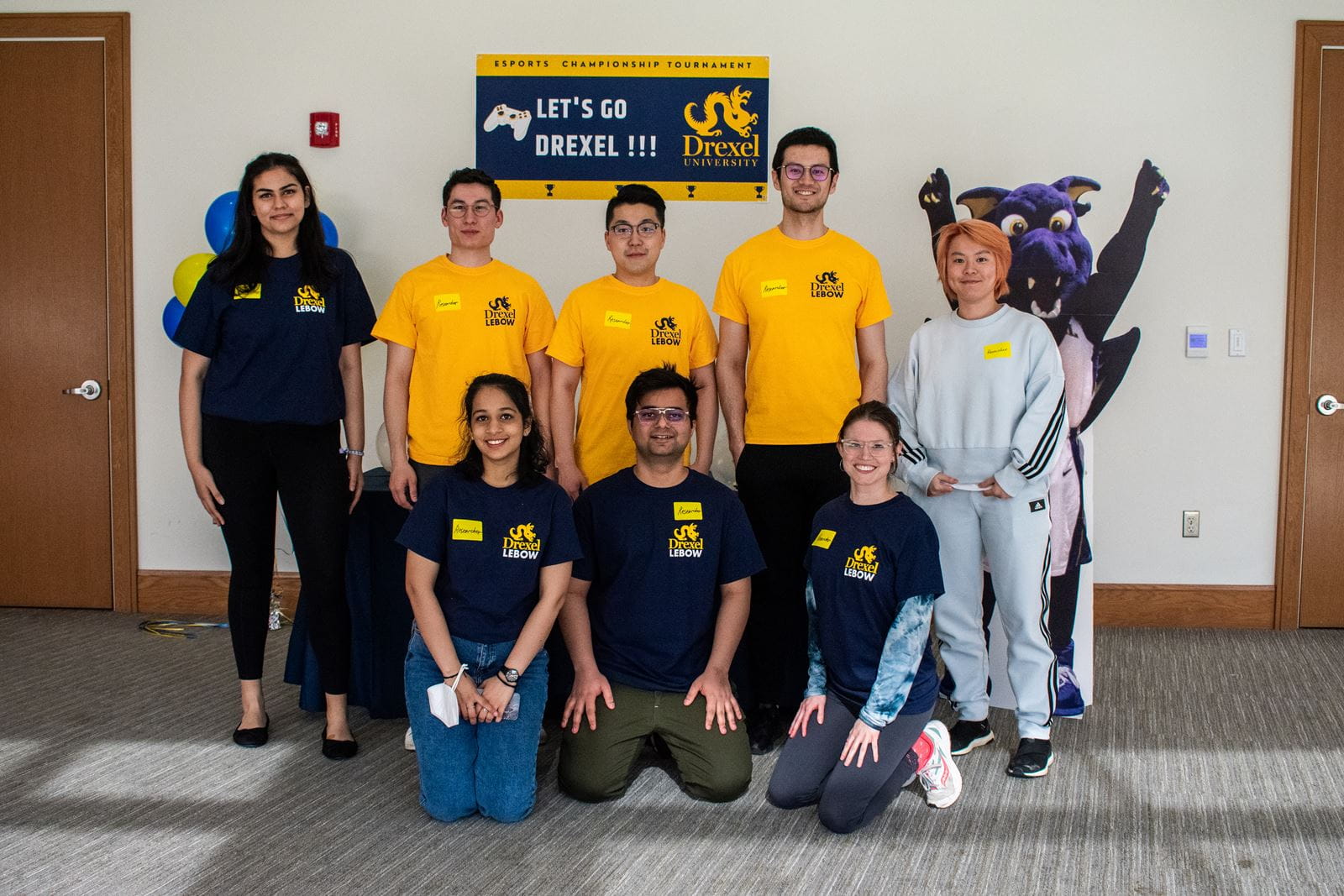 A group of students standing in front of a sign that reads "E-Sports Championship Tournament: Let's go Drexel!!!"