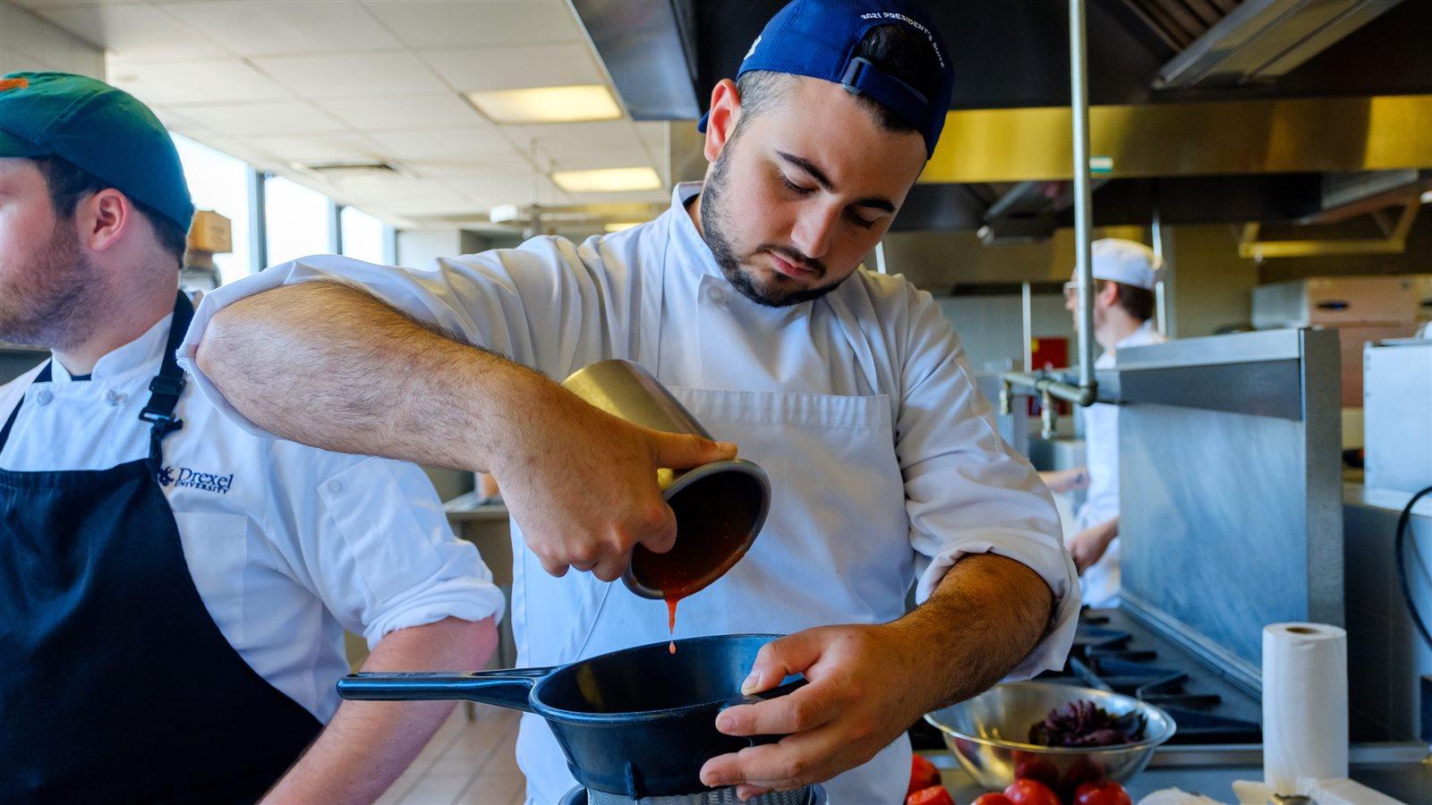Student Zac Cohen works on a trial-run dish before the final presentation to Longwood Gardens. 