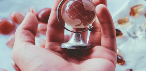 a hand holding a tiny globe