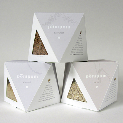 Jermaine Boca's PomPom Rice three packaging containers with see-through triangle sides
